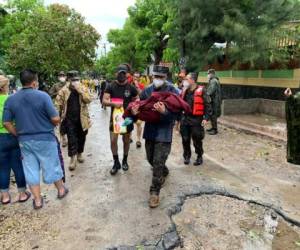 Un agente de Policía Nacional de El Salvador carga el cadáver de una niña en San Vicente, tras daños por la Tormenta Tropical Amanda.