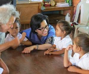 Sri Mulyani Indrawati (camisa azul) del Banco Mundial visita una escuela.