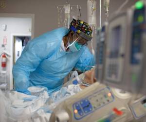 TOPSHOT - Healthcare worker Demetra Ransom comforts a patient in the Covid-19 ward at United Memorial Medical Center in Houston, Texas on December 4, 2020. (Photo by Mark Felix / AFP) (Photo by MARK FELIX/AFP /AFP via Getty Images)