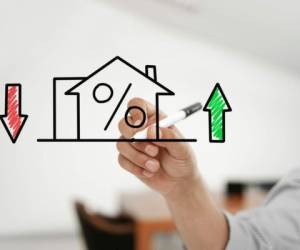 Businessman drawing 'house and mortgage rates' on a virtual glass board