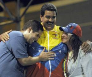 (FILES) In this file photo taken on April 06, 2013, Venezuelan acting President Nicolas Maduro (C) embraces his wife Cilia Flores (L) and son Nicolas Maduro during a campaign rally in Puerto Ordaz, Bolivar state, Venezuela. - The US imposed sanctions on June 28, 2019, on the son of Venezuelan President Nicolas Maduro for serving in his father's 'illegitimate regime.''Maduro relies on his son Nicolasito and others close to his authoritarian regime to maintain a stranglehold on the economy and suppress the people of Venezuela,' US Treasury Secretary Steven Mnuchin said in announcing the action. (Photo by Juan BARRETO / AFP)