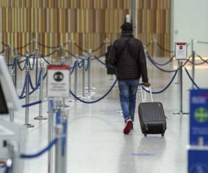 Travellers queue at a check-in counter at OR Tambo International Airport in Johannesburg on November 27, 2021, after several countries banned flights from South Africa following the discovery of a new Covid-19 variant Omicron. - A flurry of countries around the world have banned ban flights from southern Africa following the discovery of the variant, including the United States, Canada, Australia,Thailand, Brazil and several European countries. The main countries targeted by the shutdown include South Africa, Botswana, eSwatini (Swaziland), Lesotho, Namibia, Zambia, Mozambique, Malawi and Zimbabwe. (Photo by Phill Magakoe / AFP)