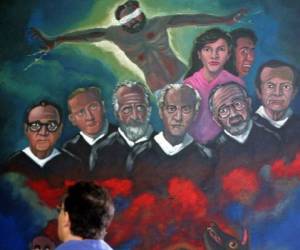 Un hombre observa una pintura mural el 16 de noviembre de 2006 en la Capilla de la Universidad Centroamericana, con los rostros de seis sacerdotes jesuitas españoles y dos de sus colaboradoras, asesinados por el ejercito Salvadoreño en 1989 en San Salvador. A 17 años del asesinato de seis sacerdotes jesuitas y dos mujeres, cometido por militares, la Universidad Centroamericana (UCA) pide justicia para los responsables intelectuales, mientras decenas de salvadoreños comenzaron a desfilar por la tumba de los mártires. AFP PHOTO/Yuri CORTEZ / AFP PHOTO / YURI CORTEZ