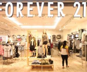 A shopper exits a Forever 21 store at a shopping mall in Montebello, California on September 30, 2019 a day after the fashion retailer filed for Chapter 11 bankruptcy protection. - Global fast-fashion retailer Forever 21 said it was filing for voluntary bankruptcy Sunday, the latest US brick-and-mortar chain to embark on restructuring as shoppers migrate online. (Photo by Frederic J. BROWN / AFP)