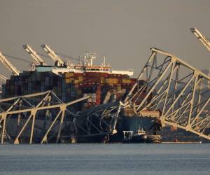 <i>El carguero Dali permanece atrapado bajo los restos retorcidos del puente Francis Scott Key, que fue destruido cuando el barco chocó con él a principios de esta semana, el 29 de marzo de 2024 en Baltimore, Maryland. FOTO Chip Somodevilla/Getty Images/AFP</i>