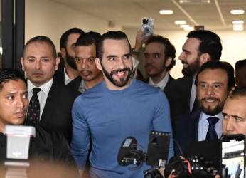 <i>El presidente de El Salvador, Nayib Bukele (centro), sonríe al llegar a la sede del Tribunal Supremo Electoral para registrarse para las próximas elecciones, en San Salvador, el 26 de octubre de 2023. FOTO MARVIN RECINOS / AFP</i>