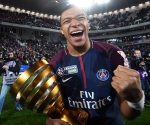 <i>(ARCHIVOS) El delantero francés del Paris Saint-Germain, Kylian Mbappé, sostiene el trofeo mientras celebra después de la victoria en el partido de fútbol final de la Copa de la Liga francesa entre Mónaco (ASM) y Paris Saint-Germain (PSG) en el estadio Matmut Atlantique en Burdeos, suroeste de Francia. FOTO FRANCK FIFE/AFP</i>