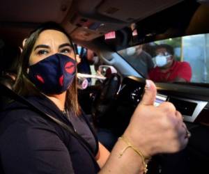 Honduran former first lady (2010-2014) Rosa Elena Bonilla, wife of Honduran former president Porfirio Lobo, gives the thumb up as she gets on a car after being freed in Tamara, 20 km north of Tegucigalpa, on July 23, 2020. - Bonilla, who had been convicted on corruption charges, was released from preventive detention Thursday and will face another trial. (Photo by ORLANDO SIERRA / AFP)