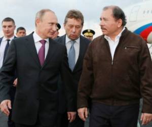 A handout photo distributed by the Presidencia de Nicaragua shows Russian President Vladimir Putin (2L) walking with the President of Nicaragua Daniel Ortega (R) upon Putin's arrival at the Augusto C. Sandino Airport in Managua, on July 11, 2014. They spoke of their commitment to peace, the welfare of the people, fighting poverty, drug trafficking, organized crime and terrorism. Putin arrived in Nicaragua is part of his Latin American tour, to Cuba, Argentina and Brazil where he will participate in the Summit of the BRICS, which brings together economic powers such as Brazil, Russia, India, China and South Africa. Putin will attend the closing of the World Cup 2014, taking into account that Russia will host the next championship in 2018. AFP PHOTO/ Presidencia de Nicaragua / César PEREZ / HANDOUT == RESTRICTED TO EDITORIAL USE - MANDATORY CREDIT ' AFP PHOTO / PRESIDENCIA DE NICARAGUA / César PEREZ' - NO MARKETING NO ADVERTISING CAMPAIGNS - DISTRIBUTED AS A SERVICE TO CLIENTS == / AFP PHOTO / Presidencia de Nicaragua / CESAR PEREZ