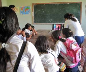 Estudiantes de Bolivia trabajan alrededor de una computadora.