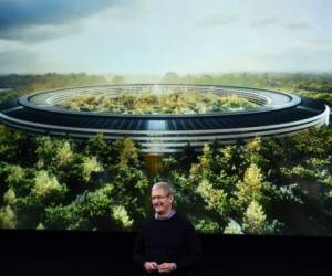 Apple CEO Tim Cook stands in front of a slide of the company's new campus which is under construction during a media event at Apple headquarters in Cupertino, California on March 21, 2016. / AFP PHOTO / Josh Edelson