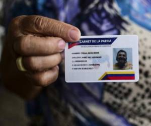 Trina Paez muestra su 'Carnet de la Patria', carné electrónico para obtener los beneficios sociales del Gobierno. Paez apoya la Asamblea Constituyente de Maduro. AFP PHOTO / RONALDO SCHEMIDT