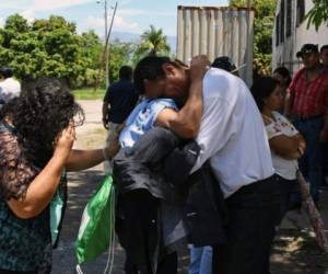 An Honduran immigrant is received by his family at the Ramon Villeda Morales airport, in San Pedro Sula, 200 kilometres north of Tegucigalpa, after being deported from the US, on June 22, 2018. 238 Honduran citizens deported from the US arrived on Friday back to their country. According to their testimony they travelled hand, foot and waist chained. / AFP PHOTO / ORLANDO SIERRA