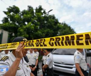 <i>Policías acordonan el ingreso a la sede del Tribunal Supremo Electoral mientras fiscales del Ministerio Público realizan un allanamiento en Ciudad de Guatemala el 29 de septiembre de 2023. FOTO JOHAN ORDONEZ / AFP</i>