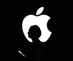 (FILES) In this file photo a reporter walks by an Apple logo during a media event in San Francisco, California on September 9, 2015. \ - Apple on August 19, 2020 became the first US company to reach $2 trillion in market value in the latest demonstration of how tech giants have benefited amid the upheaval of the coronavirus. The iPhone maker attained the distinction in mid-morning trading and was up 1.3 percent at $468.34 near 1500 GMT. In March 2018, Apple became the first giant to hit $1 trillion in market value. (Photo by Josh Edelson / AFP)