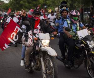 Supporters of the Sandinista National Liberation Front (FSLN) take part in a caravan in Managua, on July 18, 2020 on the eve of the the 41st anniversary of the Sandinista Revolution. - Nicaragua will celebrate on Sunday the 41st anniversary of the Sandinista Revolution, for the first time without a public event for the speech of Nicaraguan President Daniel Ortega due to the COVID-19 pandemic. (Photo by INTI OCON / AFP)