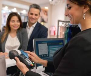 Happy couple shopping at a clothing store and paying by card at the cashier - lifestyle concepts. **DESIGN ON CREDIT CARD AND SCREEN WERE MADE FROM SCRATCH BY US**