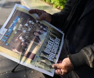 <i>Un hombre muestra un periódico con la portada que dice Presidente Bukele en el centro histórico de San Salvador el 5 de febrero de 2024. FOTO Marvin RECINOS / AFP</i>
