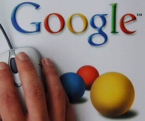 <i>Una mano sobre una alfombrilla de ordenador con el logo de Google. EFE/Boris Roessler</i>