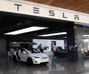 (FILES) In this file photo taken on April 25, 2019 People stand in a Tesla showroom at a shopping mall in Los Angeles. - Tesla shares dived around 20 percent in early afternoon trading on February 5, 2020, giving back some of the gains the electric-car maker racked up since October. Shares stood at $723.92, down 18.3 percent around 1835 GMT, reversing a nearly unbroken trend over the last four months that accelerated this week when the stock jumped more than 36 percent in a two-day surge. (Photo by Mark RALSTON / AFP)