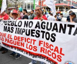 Workers of Costa Rican oil refinery Recope demonstrate outside a refinery in Cartago, Costa Rica, on September 19, 2018 during an indefinite strike called by the country's unions against a tax reform.The unions of the Costa Rican public sector began an indefinite strike on September 10, in opposition to a tax reform project which would mean an increase of taxes to face the bulky fiscal deficit. Due to the strike, gasoline is scarce in many gas stations across the country. / AFP PHOTO / Ezequiel BECERRA