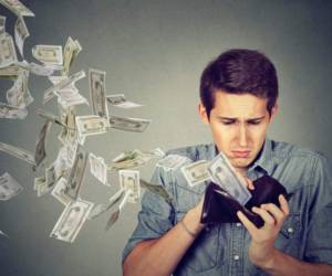 Sad man looking at his wallet with money dollar banknotes flying out away