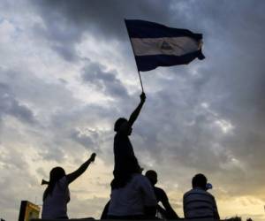 Students flutter a Nicaraguan national flag as they take part in a protest against the government of Nicaraguan President Daniel Ortega in Managua on May 15, 2018.Ortega will attend long-awaited crisis talks with the opposition after nearly a month of violence that has left scores dead, officials said Tuesday. / AFP PHOTO / DIANA ULLOA