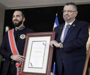 <i>ARCHIVO. El presidente de Costa Rica, Rodrigo Chaves (d), condecora a su homólogo de El Salvador, Nayib Bukele, este lunes en San José (Costa Rica). El presidente Chaves condecoró a Bukele por los avances de ese país en seguridad, con la Orden Nacional Juan Mora Fernández en el grado Gran Cruz Placa de Oro, la máxima distinción que Costa Rica otorga a jefes de Estado o de Gobierno distinguidos. EFE/ Jeffrey Arguedas</i>