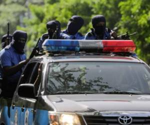 Riot police stand by as members of the Nicaraguan Medical Unit (UMN) and anti-government protesters demostrate calling for the re-employment of 405 health workers who lost their jobs for assisting protesters during last year's deadly uprising against President Daniel Ortega, in Managua on August 3, 2019. (Photo by INTI OCON / AFP)