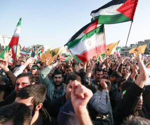 <i>La gente ondea banderas palestinas y de Hezbolá como protesta en Teherán en apoyo de los palestinos en Gaza el 18 de octubre de 2023. Miles de personas se manifestaron en todo el mundo árabe y musulmán el 18 de octubre para protestar por la muerte de cientos de personas en una huelga en un hospital de Gaza. que culpan a Israel, a pesar de sus negaciones.ATTA KENARE / AFP</i>