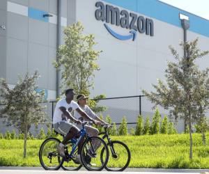 <i>Fotografía de archivo del 5 de enero de 2023 de dos personas circulando en bicicleta frente a un centro logístico de Amazon en Florida (EE.UU.). Zoox, la empresa de vehículos autónomos propiedad de Amazon, inauguró una planta que se centrará en la producción de robotaxis en California, con la que busca hacer competencia a Waymo, según apuntan este miércoles los medios locales. EFE/EPA/ CRISTOBAL HERRERA-ULASHKEVICH / ARCHIVO</i>