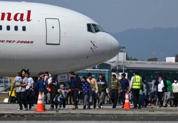 <i>Migrantes guatemaltecos deportados desde Estados Unidos caminan sobre la pista luego de aterrizar en la Base de la Fuerza Aérea en la Ciudad de Guatemala en el primer vuelo de deportados del año el 3 de enero de 2024. FOTO Johan ORDÓNEZ / AFP</i>