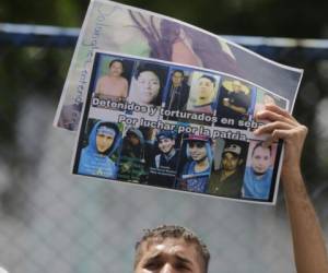 A relative of imprisoned protesters hold their portraits as he demand their release outside 'El Chipote' prison in Managua, on July 2, 2018. More than 200 people have been killed and some 2,000 people have been imprisoned since the start of a popular uprising against Nicaraguan President Daniel Ortega in April. / AFP PHOTO / INTI OCON