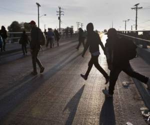 TIJUANA, MEXICO - NOVEMBER 17: Members of the migrant caravan walk to make requests for political asylum at the U.S.-Mexico border on November 17, 2018 in Tijuana, Mexico. Parts of the caravan have been arriving to Tijuana at the U.S. border, after traveling more than a month through Central America and Mexico. John Moore/Getty Images/AFP