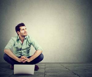 young man with laptop sitting on floor