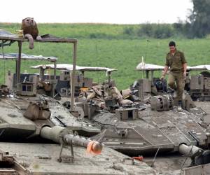 <i>ARCHIVO Un soldado israelí camina encima de un tanque estacionado en un área a lo largo de la frontera con la Franja de Gaza en el sur de Israel el 10 de abril de 2024, en medio del conflicto en curso en el territorio palestino entre Israel y el grupo militante Hamás.FOTO JACK GUEZ / AFP</i>