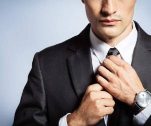 Man in suit fixing his tie.