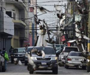 Catholic faithfuls ride a car procession to commemorate Jesus Christ crucifixion during Good Friday, within the government restrictions to fight the spread of the COVID-19 coronavirus, in Tegucigalpa, on April 10, 2020. (Photo by ORLANDO SIERRA / AFP)