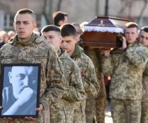 Voluntarios de la milicia de Ucrania cargan los restos de Taras Bobanych, que murió en el conflicto contra Rusia en Lviv el 13 de abril de 2022, en medio de la invasión de Rusia a Ucrania. (Photo by Yuriy Dyachyshyn / AFP)
