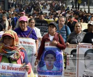 Students and relatives of the 43 students of the teaching training school in Ayotzinapa who went missing on September 26, 2014, protest ahead of the fifth anniversary of their disappearance, in Mexico City on September 25, 2019. - The Mexican prosecutor-general's office said -last September 18- it will reinvestigate 'almost from scratch' the disappearance and suspected massacre of 43 students in 2014, a case that still haunts the country. (Photo by ALFREDO ESTRELLA / AFP)