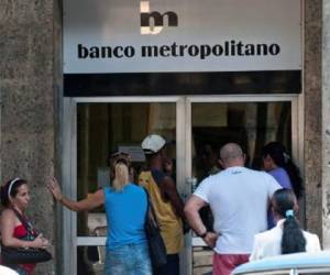Cubanos esperan en la puerta de entrada del Banco Metropolitano. (Foto: AFP)