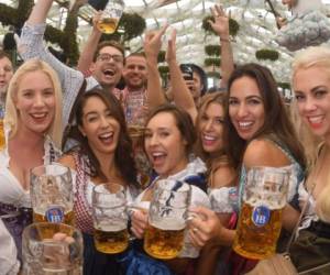 People drink the first mugs of beer after the official opening of the 184th Oktoberfest, Munich's annual beer festival, on September 16, 2017 in Munich, southern Germany.The world's largest beer festival is held from September 16 until October 3, 2017. / AFP PHOTO / dpa / Felix Hörhager / Germany OUT