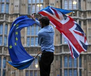 (FILES) In this file photo taken on June 28, 2016 A man waves both a Union flag and a European flag together on College Green outside The Houses of Parliament at an anti-Brexit protest in central London on June 28, 2016. - British Prime Minister Boris Johnson announced Wednesday that the suspension of parliament would be extended until October 14 -- just two weeks before the UK is set to leave the EU -- enraging anti-Brexit MPs. (Photo by JUSTIN TALLIS / AFP)