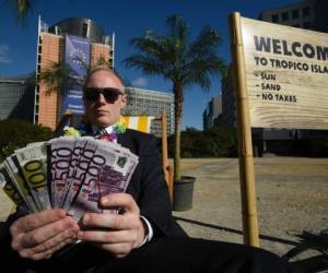 An activist performs as a client of an offshore company during a protest of the non-governmental organizations 'Oxfam' and 'Transparency International' in front of the European Commission headquarters in Brussels, on April 12, 2016. Following the Panama Papers revelations, Oxfam criticizes the EU Commission's delay of financial reforms. Commissioner Jonathan Hill is expected to present a list of reforms in Strasbourg, France, later on April 12. / AFP PHOTO / JOHN THYS