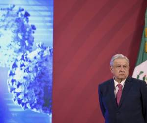 El presidente mexicano Andrés Manuel López Obrador junto a la bandera mexicana antes de su conferencia de prensa diaria en el Palacio Nacional de la Ciudad de México el 8 de diciembre de 2020. - El gobierno mexicano presentó su plan de vacunación contra el Covid-19. (Foto de ALFREDO ESTRELLA / AFP)