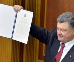 El presidente Petro Poroshenko muestra el acuerdo con la Unión Europea tras su aprobación, este martes 16 de septiembre en el Parlamento de Kiev. (Foto: AFP).