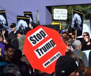 People gather and hold placards voicing their displeasure with the recent US election results before a march on International Migrants Day on December 18, 2016 in Los Angeles. / AFP PHOTO / Frederic J. BROWN