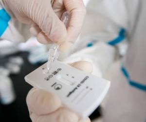 A health worker in protective clothes evaluates a Covid-19 antigen test on the novel coronavirus on September 23, 2020 in Vienna, on the sidelines of the Austrian Media Days. (Photo by GEORG HOCHMUTH / APA / AFP) / Austria OUT