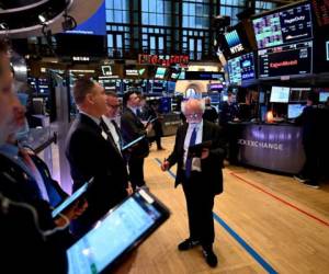 Traders work during the opening bell at the New York Stock Exchange (NYSE) on March 16, 2020 at Wall Street in New York City. - Trading on Wall Street was halted immediately after the opening bell Monday, as stocks posted steep losses following emergency moves by the Federal Reserve to try to avert a recession due to the coronavirus pandemic.Just after the opening bell, the S&P 500 was at 2,490.47, a drop of 8.1 percent and beyond the seven percent loss that automatically triggers a 15-minute trading halt. (Photo by Johannes EISELE / AFP)