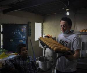 A member of the Portillo family make bread and pizzas to be sold to neighbours and different businesses, at a bakery in San Jacinto neighbourhood in San Salvador on April 24, 2020 during the COVID-19 coronavirus pandemic. - According to a projection of the World Food Program, 265 million people could suffer from hunger in 2020, that is to say almost twice more than in 2019, due to the economic impact of this health crisis. (Photo by Yuri CORTEZ / AFP)